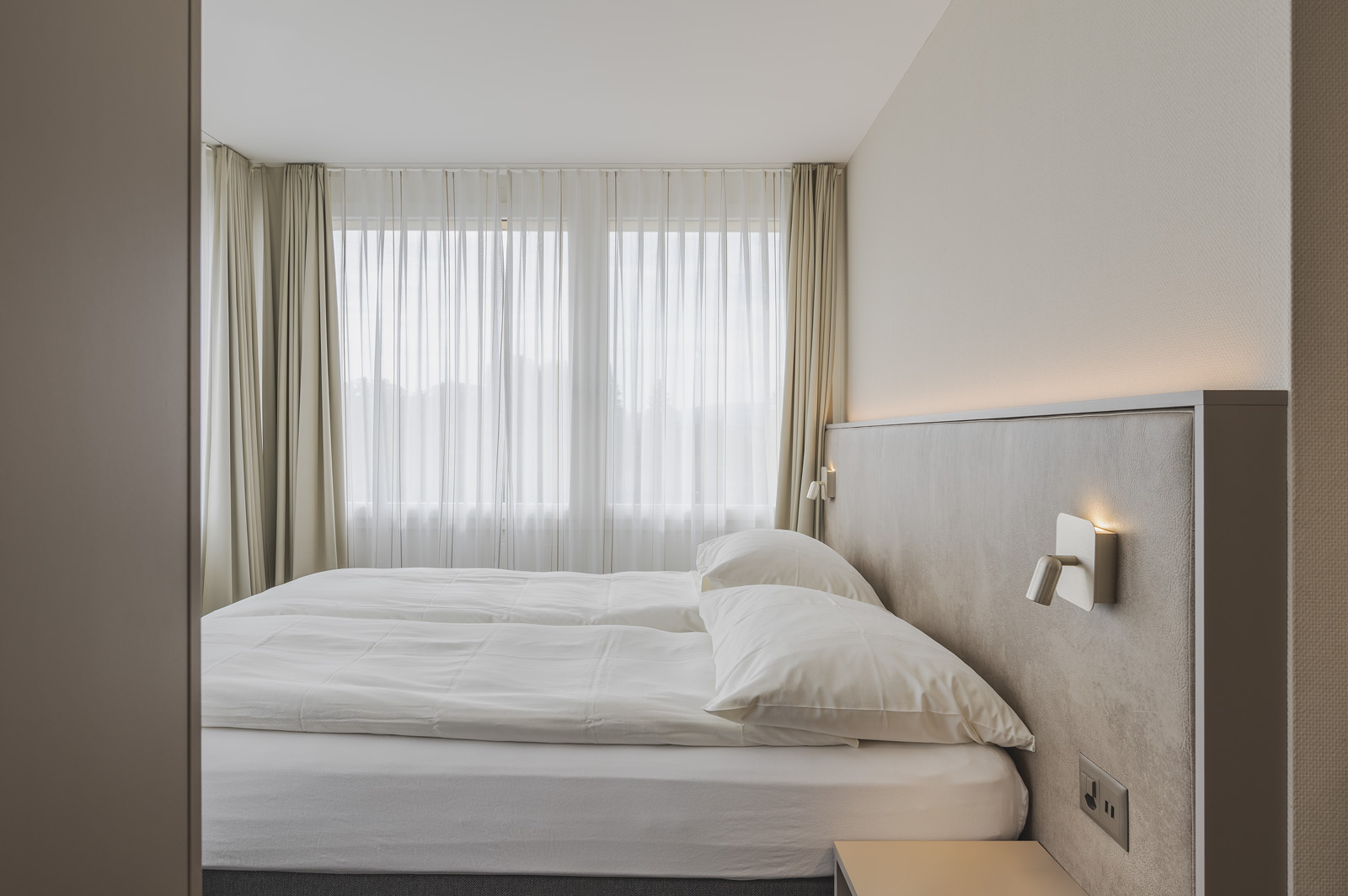 Modern bedroom with sheer curtains at Amanthos Living